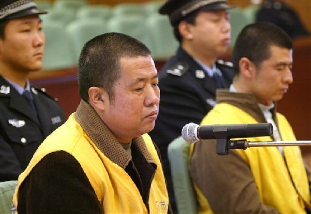 In this Dec. 30, 2008 file photo released by China's Xinhua News Agency, Geng Jinping, left front, manager of a milk production base and his brother Geng Jinzhu, right front, a driver at the base, stand trial at the Shijiazhuang Intermediate People's Court in Shijiazhuang, capital of north China's Hebei Province. A court in China upheld convictions against two brothers given hefty sentences including the death penalty for involvement in the country's deadly tainted milk scandal as two others appealed Thursday, March 26, 2009. (AP Photo/Xinhua, Ding Lixin, File)