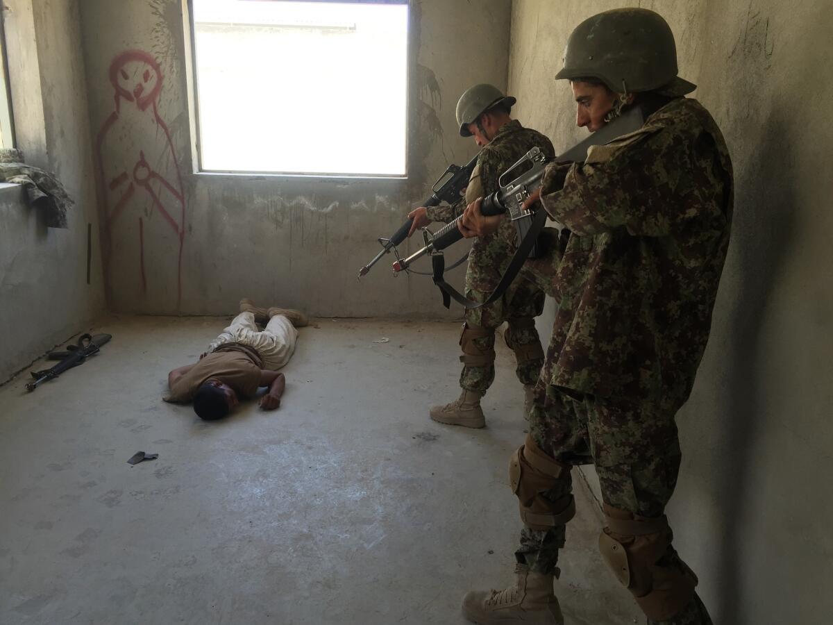 Afghan army recruits conduct a mock house raid at the main military training center in Kabul.
