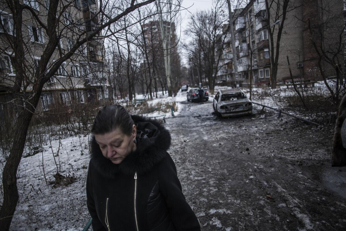 A woman walks through a residential area hit by Ukrainian army artillery in the Voroshilovsky area of Donetsk, Ukraine, on Sunday.
