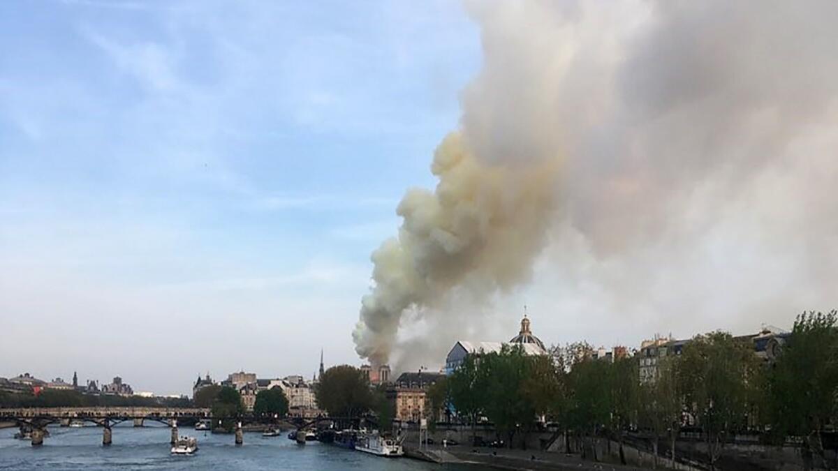 Flames and smoke are seen billowing from the roof at Notre Dame Cathedral in Paris on Monday.