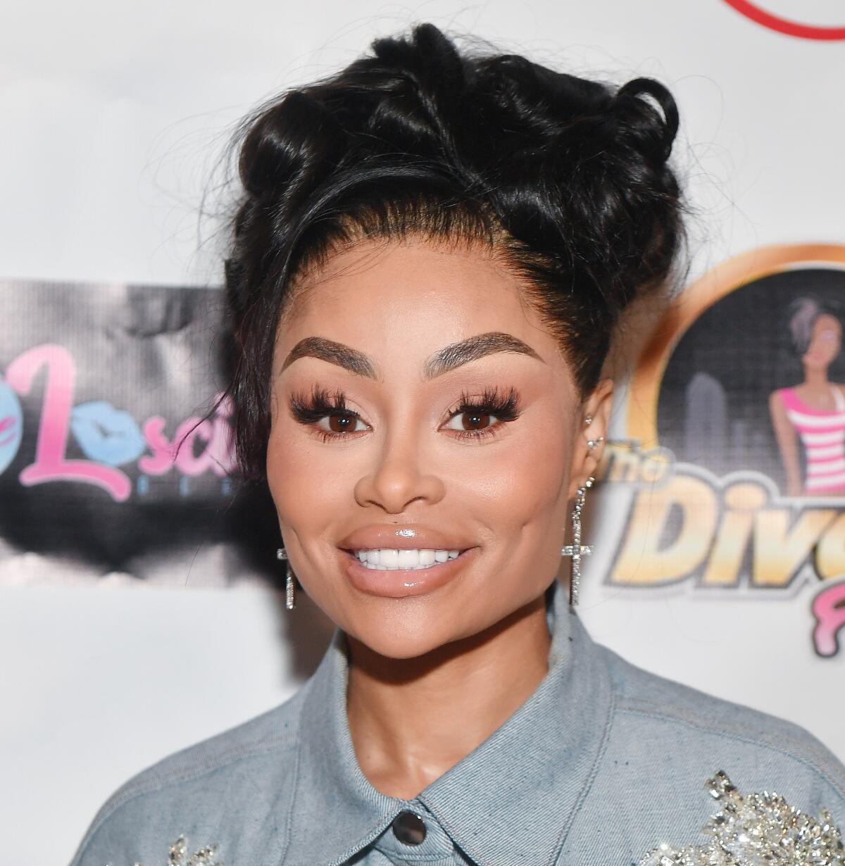 Blac Chyna smiles with her hair in a messy updo