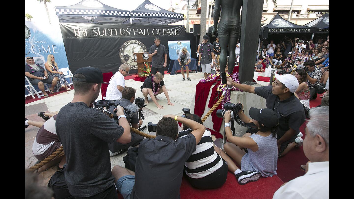 2017 inductee Mick Fanning presses his hands into the cement during the Surfers' Hall of Fame ceremony in front of Huntington Surf and Sport in downtown Huntington Beach on Friday.