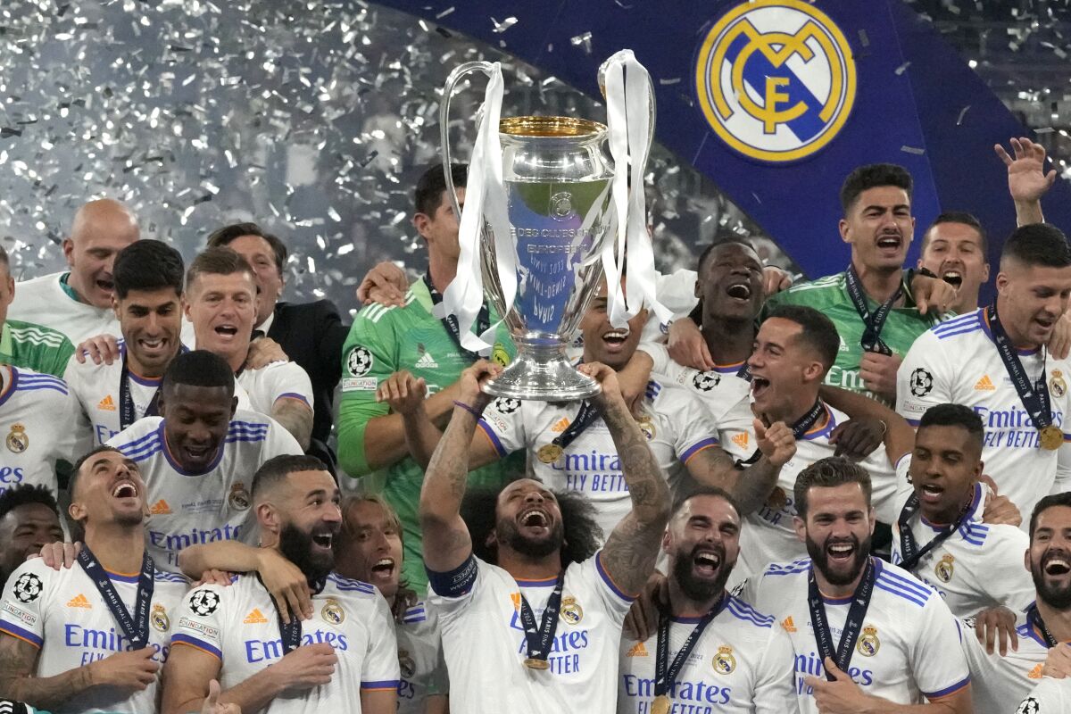 Real Madrid's Marcelo lifts the trophy as players celebrate winning the Champions League final soccer match between Liverpool and Real Madrid at the Stade de France in Saint Denis near Paris, Saturday, May 28, 2022. (AP Photo/Frank Augstein)