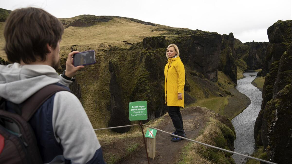 Russian tourist Nadia Kazachenok poses for a May 1 photograph by Mikhail Samarin at Fjadrárgljúfur Canyon in Iceland. The canyon is closed until at least June 1, but tourists were quick to sneak in when the ranger went off duty.