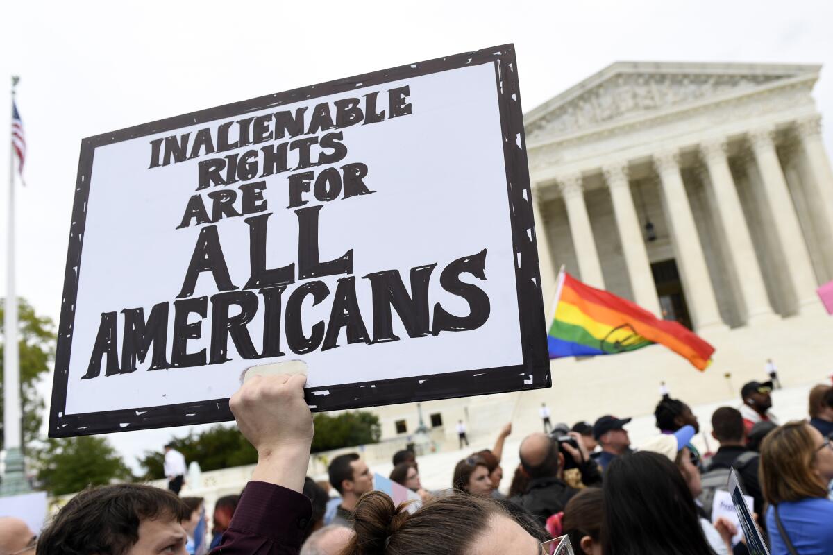 Activists gather outside the Supreme Court in October 2019 as the justices heard arguments in an LGBTQ rights case.