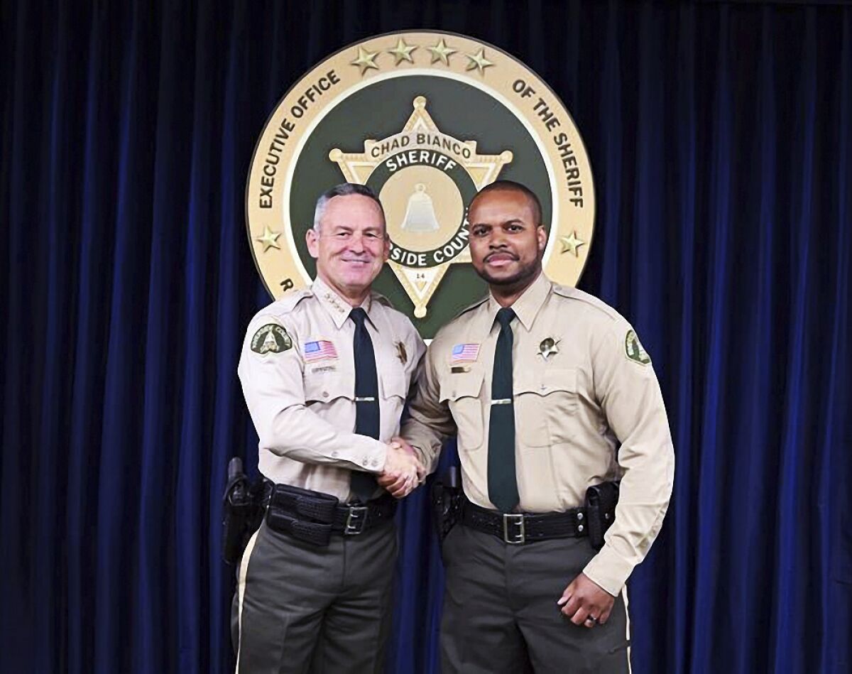 In this undated photo provided by the Riverside County Sheriff, Deputy Darnell Calhoun, right, poses with Riverside County Sheriff Chad Biano, left, in Riverside, Calif. Riverside County Sheriff's Deputy Darnell Calhoun was shot and killed Friday, Jan. 13, 2023 just two weeks after another deputy in the department was slain in the line of duty.(Riverside County Sheriff via AP)