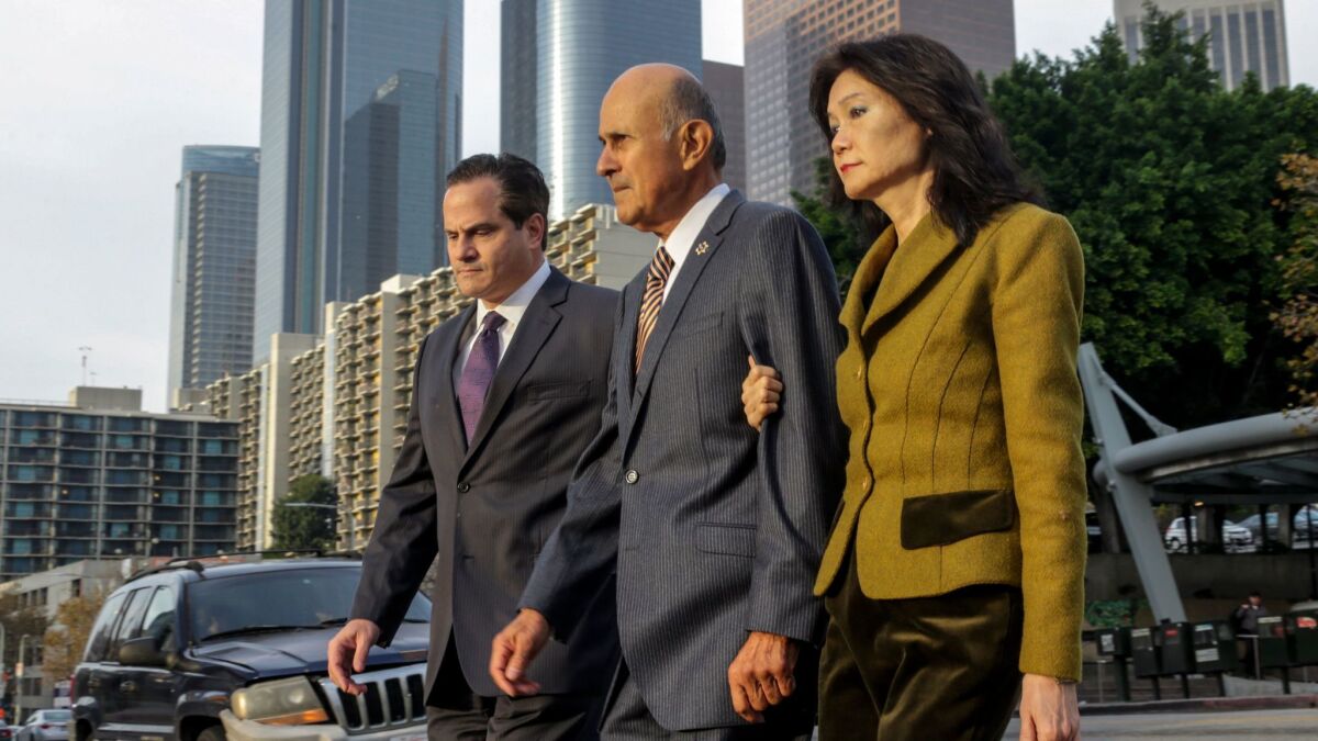 Former Los Angeles County Sheriff Lee Baca, center, flanked by his attorney Nathan J. Hochman, left, and wife Carol Chiang, as he arrives at federal court this week for his obstruction of justice trial.