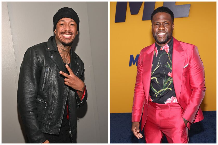Nick Cannon in a black outfit holding up a peace sign. Kevin Hart in a pink suit 