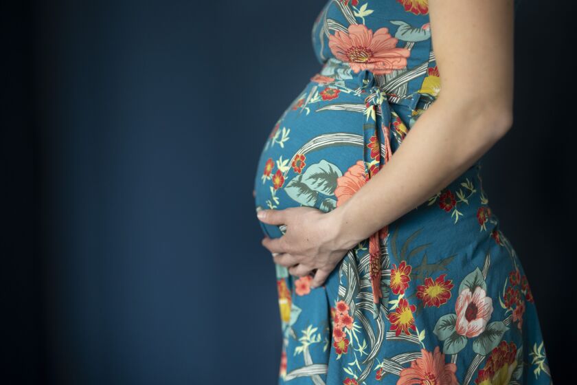 Photo illustration of a young pregnant woman holding her baby bump