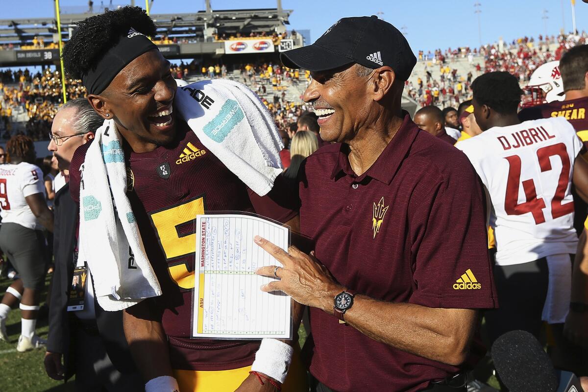 Arizona State quarterback Jayden Daniels (5) celebrates with head coach Herm Edwards, right, after a win over Washington State on Oct. 12 in Tempe, Ariz.