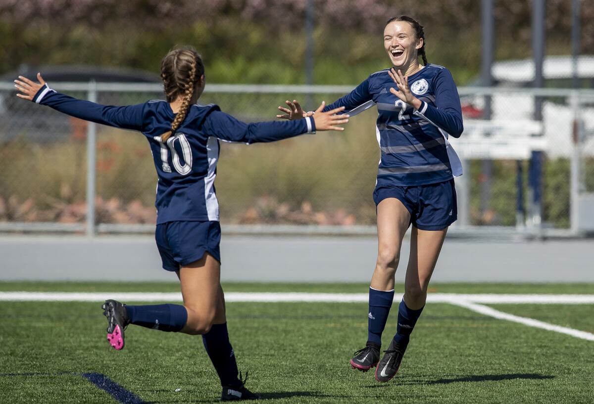 Newport Harbor's Antonella Russo, left, congratulates Laine Briggs after she scored a goal against Corona del Mar.