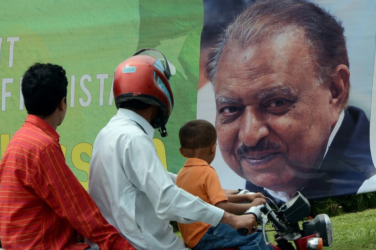 Commuters in Islamabad pass a banner congratulating Pakistan's new president, Mamnoon Hussain, who was sworn in Monday.