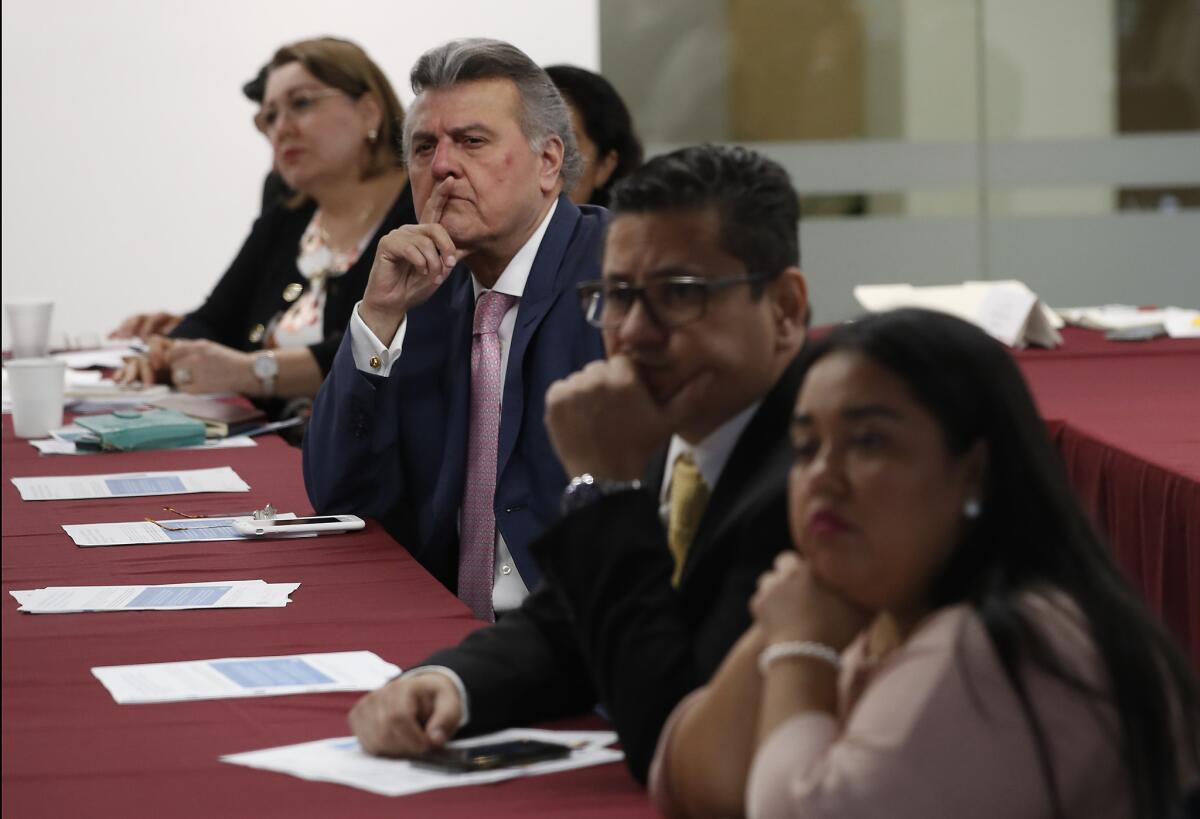 Hugo Portugal, second from left, Peru's consul general in Los Angeles, listens to speakers while attending the workshop on responding to hate crimes at L.A.'s Mexican Consulate.