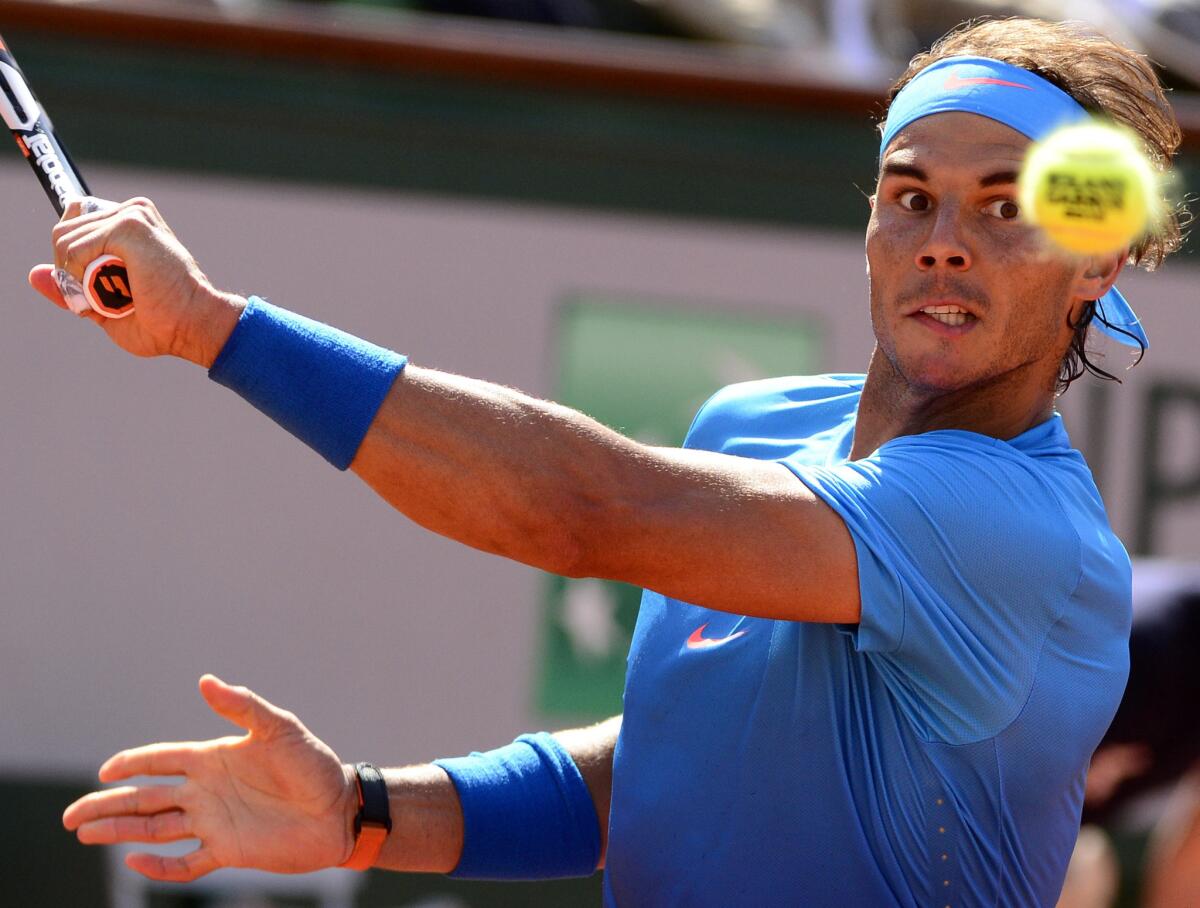 Rafael Nadal prepares to hit a backhand during a French Open quarterfinal match against Novak Djokovic at Roland Garros.