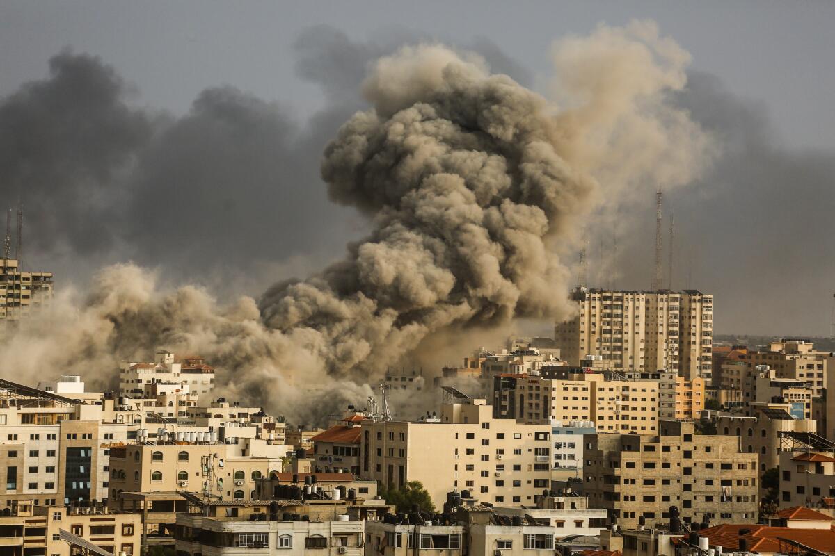 Smoke rises over multistory buildings in Gaza City during an Israeli air strike. 