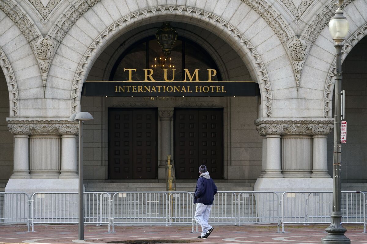 FILE - A passerby takes a look at the front of The Trump International Hotel on March 4, 2021, in Washington. A federal agency overseeing Donald Trump's Washington hotel let possible constitution violations go unchecked by failing to track millions of dollars from foreign governments that patronized the property. (AP Photo/Julio Cortez, File)