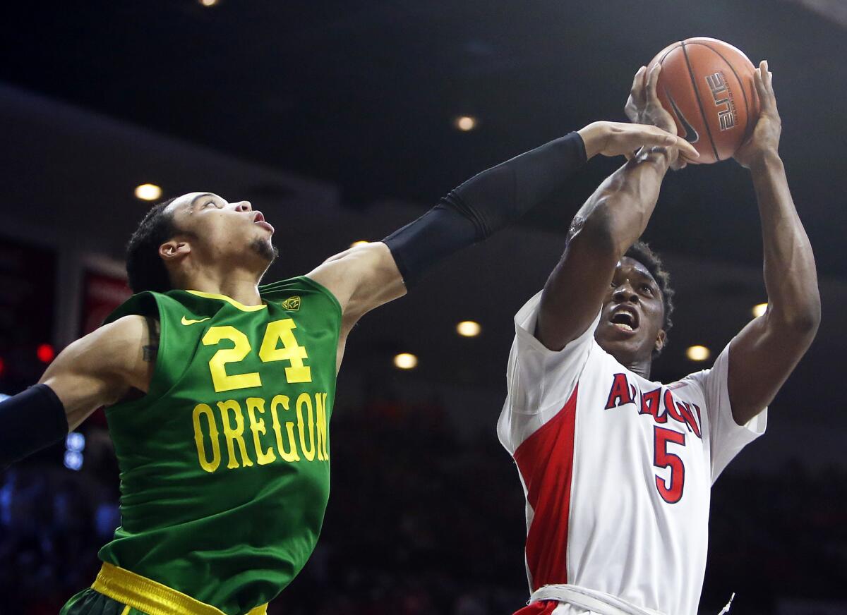 Arizona forward Stanley Johnson shoots past the outstretched arm of Oregon forward Dillon Brooks during the second half of a Pac-12 Conference game Wednesday in Tucson, Ariz.
