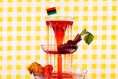 A red fountain with red foods and a hand reaching for a strawberry