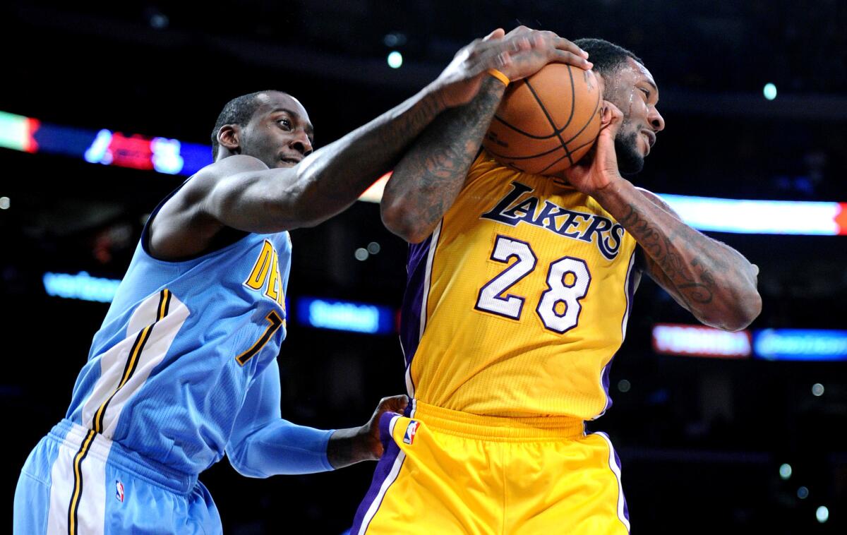 Lakers forward Tarik Black grabs a rebound from Nuggets forward J.J. Hickson during a game at Staples Center on Nov. 3.