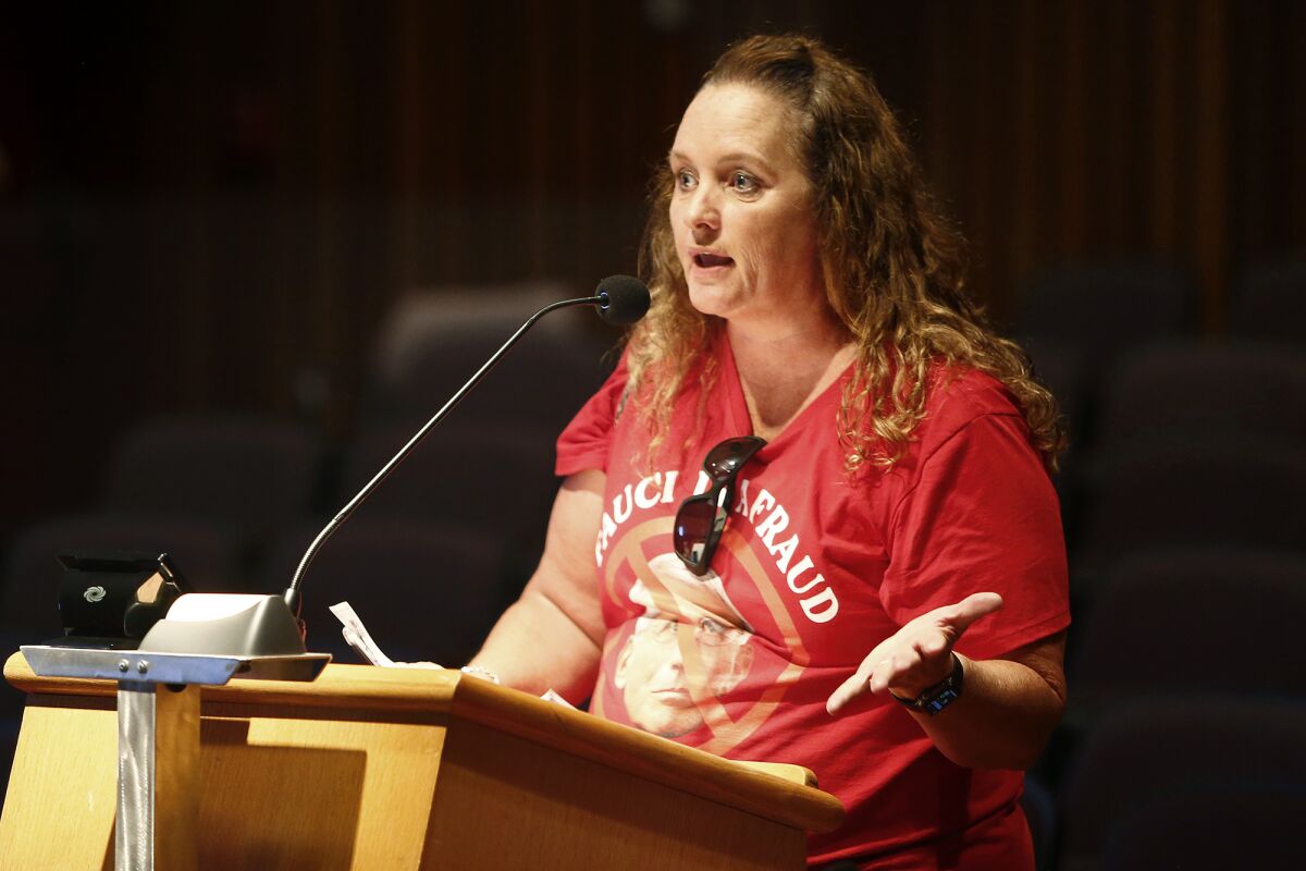 A woman wearing a shirt that says "Fauci is a fraud" speaks during an Orange County Board of Supervisors meeting.