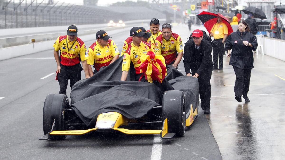 Ryan Hunter-Reay's crew pushes his car back to the garage area rain disrupts qualifying for the Indianapolis 500 at the Indianpolis Motor Speedway on Saturday.