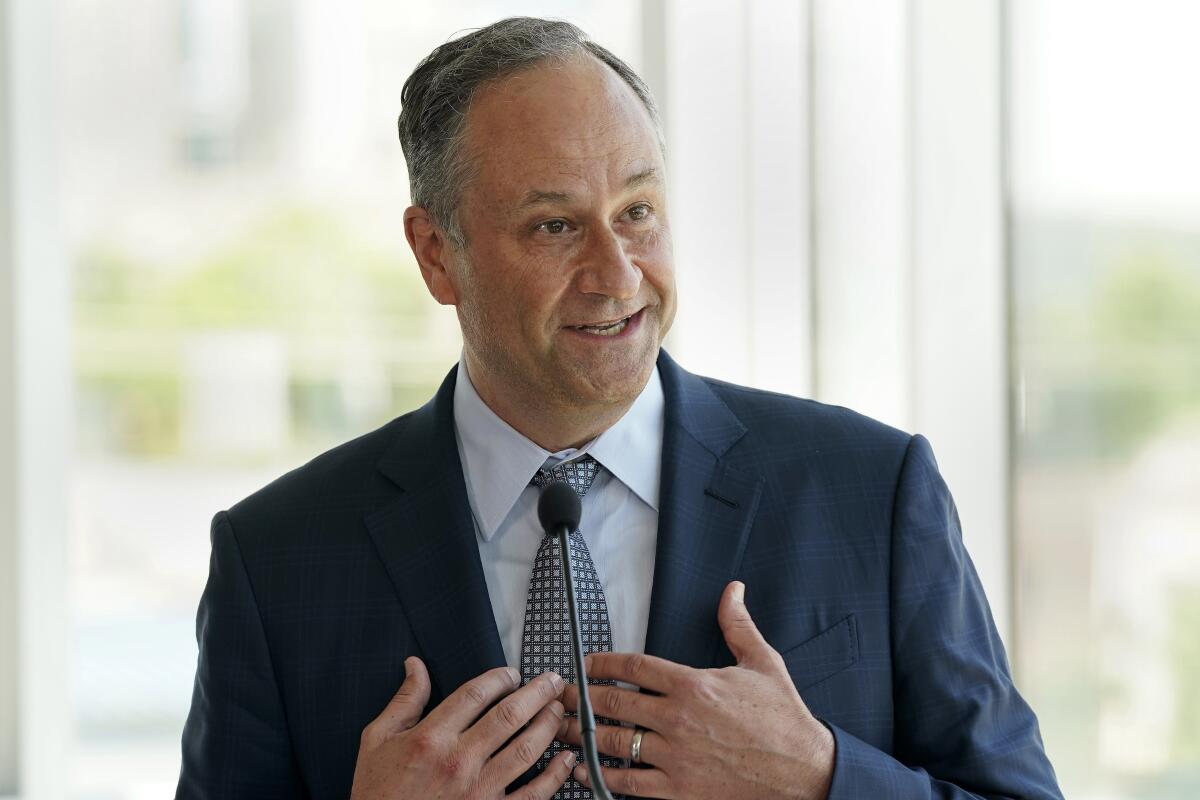 Doug Emhoff gestures as he speaks into a microphone