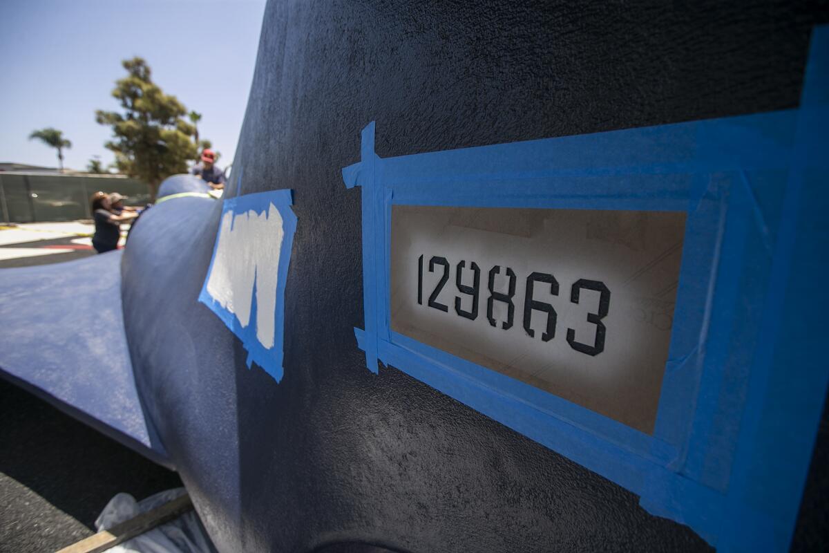 A stencil is in place on the tail of the the Korean War-era Grumman F9F Panther jet installed in Lions Park.