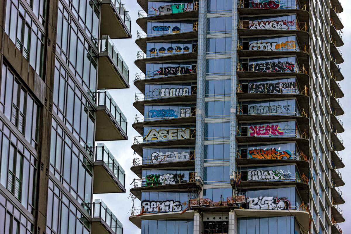 LOS ANGELES, CA - FEBRUARY 01: Taggers sprayed graffiti on at least 27 floors of a partially completed downtown Los Angeles skyscraper directly across from Crypto.com Arena at LA Live. Towers are located at the intersection of Figueroa Street. and 12th. Street on Thursday, Feb. 1, 2024 in Los Angeles, CA. (Irfan Khan / Los Angeles Times)