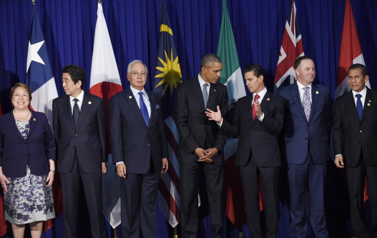 President Obama, center, talks with Mexican President Enrique Peña Nieto as other leaders of the Trans-Pacific Partnership countries stand for a group photo in Manila on Wednesday.