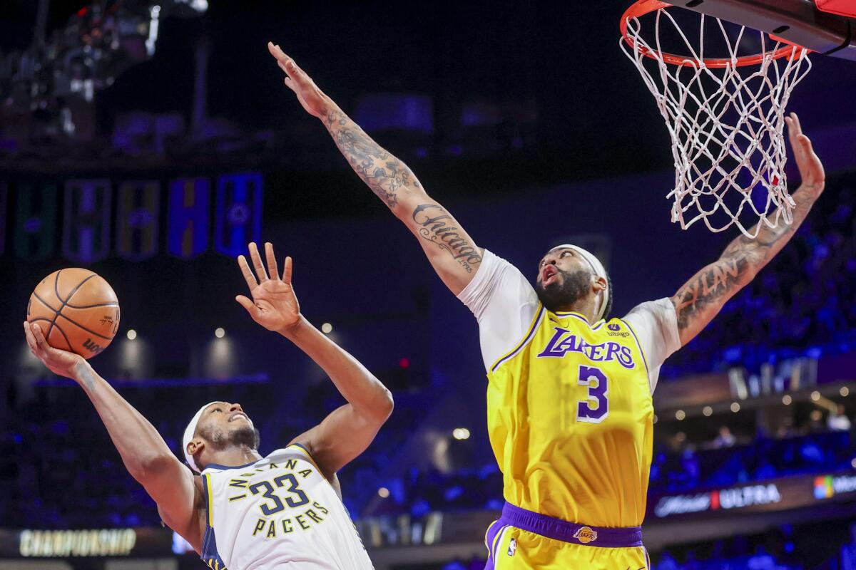 Indiana Pacers center Myles Turner, left, shoots over Lakers forward Anthony Davis during the first half.