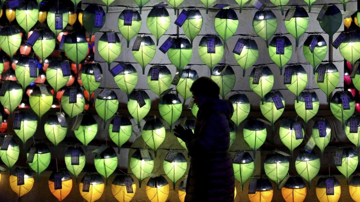 A woman prays in front of lanterns to celebrate the New Year at Jogyesa Buddhist temple in Seoul.