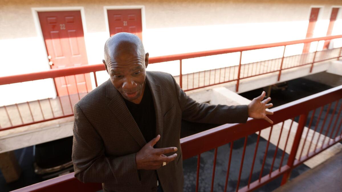 The Rev. Richard Reed, executive director of the nonprofit First to Serve, shows visitors around a former motel that is being used to house homeless women.