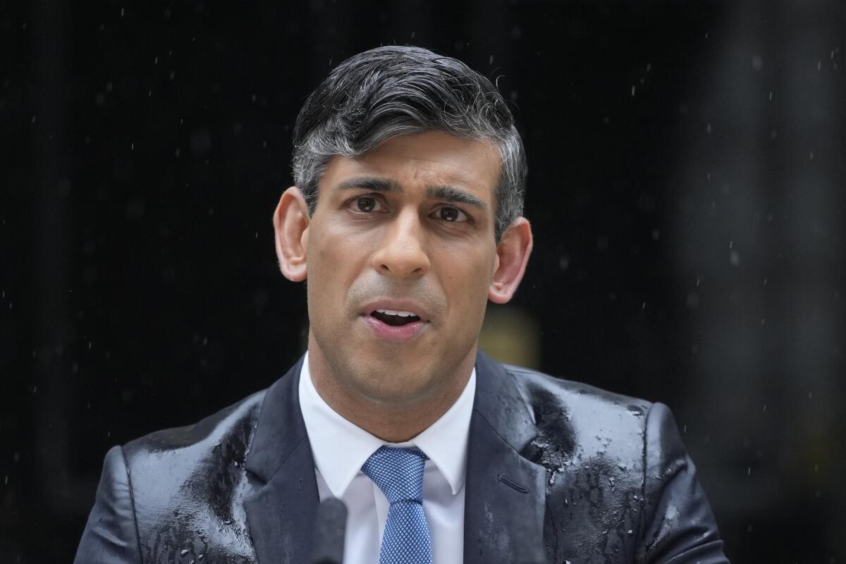 Britain's Prime Minister Rishi Sunak speaks to the media, as heavy rain falls, outside 10 Downing Street in London Wednesday, May 22, 2024, as he announces that he is to call a General Election for July 4. (AP Photo/Kin Cheung)