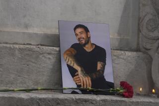 A photo of former One Direction singer Liam Payne placed with a red rose at a fan memorial in Madrid, Spain