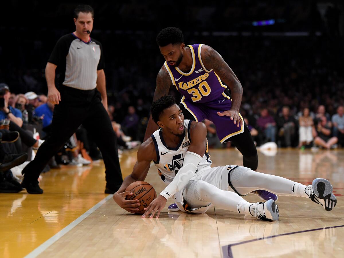 Lakers guard Troy Daniels looks to steal the ball from Jazz guard Mike Conley during their game Friday night at Staples Center.