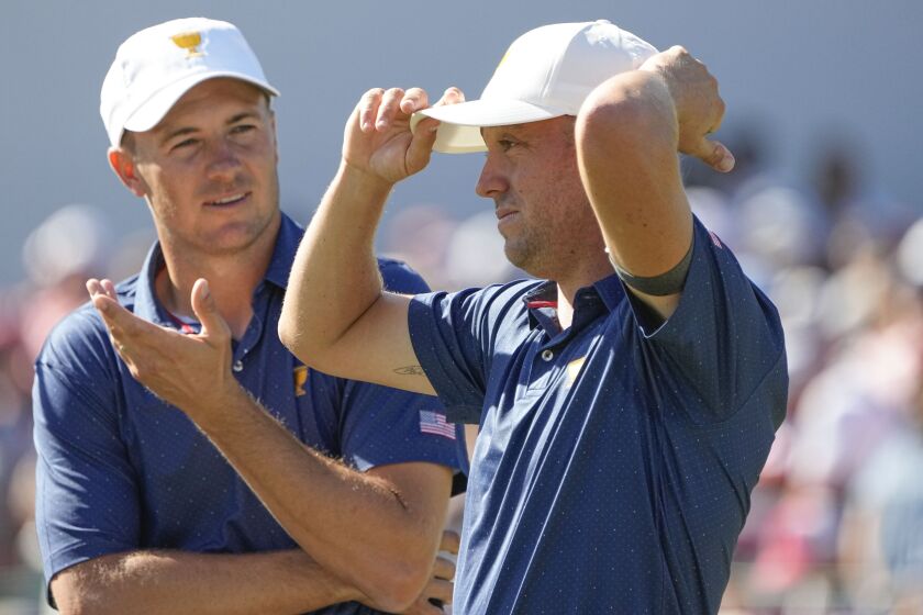 Justin Thomas and Jordan Spieth speak on the 15th green during their foursomes match at the Presidents Cup golf tournament at the Quail Hollow Club, Saturday, Sept. 24, 2022, in Charlotte, N.C. (AP Photo/Chris Carlson)