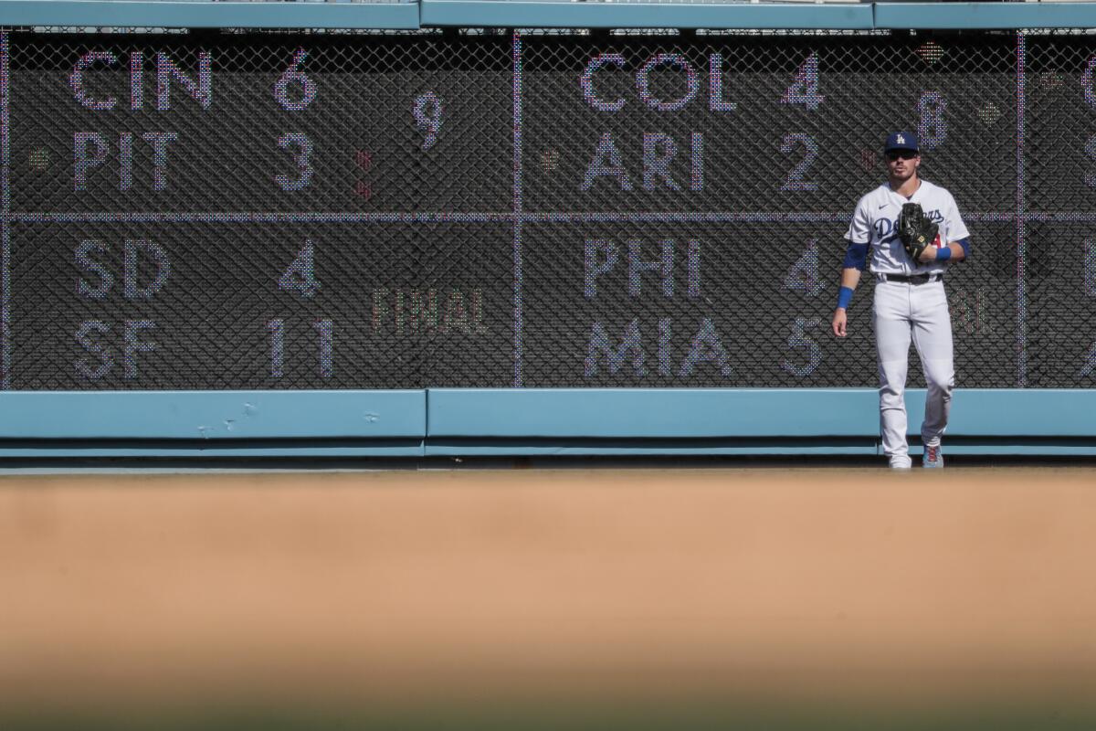 Dodgers right fielder Gavin Lux stands in front of the scoreboard during the eighth inning.
