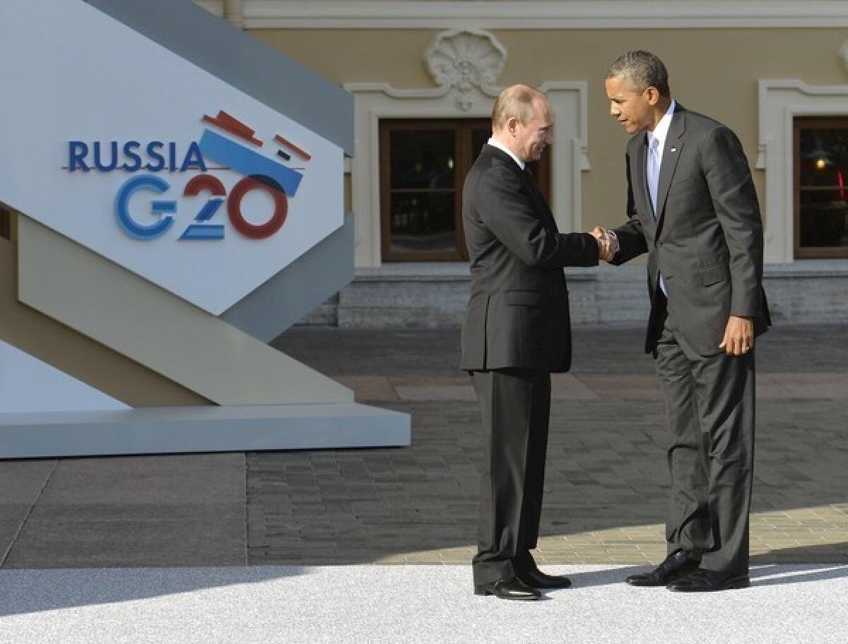 Presidents Obama and Putin exchange greetings during a procession of world leaders at the gold- and cream-colored Konstantinovsky Palace in St. Petersburg.