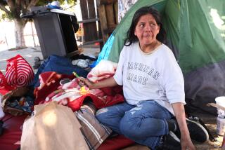 LOS ANGELES, CA - MARCH 11, 2026 - Amanda Ponce, 41, spends time at her homeless encampment along Mission Street about a block away from the Tiny Home Village where she once lived in Los Angeles on March 11, 2026. Ponce said she was kicked out of the Boyle Heights Tiny Home Village, run by Volunteers of America, a few months ago. She said her case worker said she was being kicked out for hitting another resident, but Ponce said she only lightly tapped the man after he yelled at her. (Genaro Molina/Los Angeles)