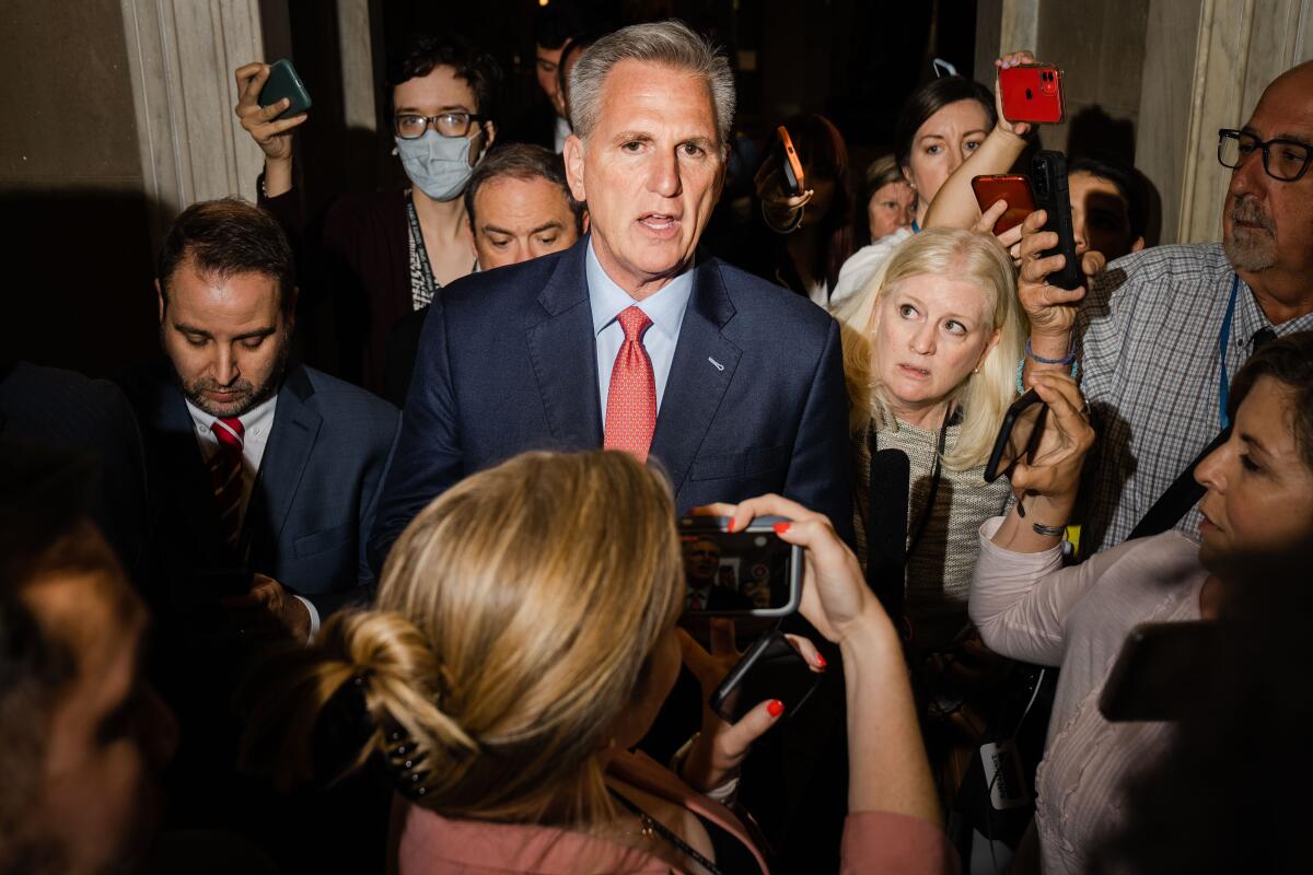 Speaker Kevin McCarthy leaves the House Chamber surrounded by people