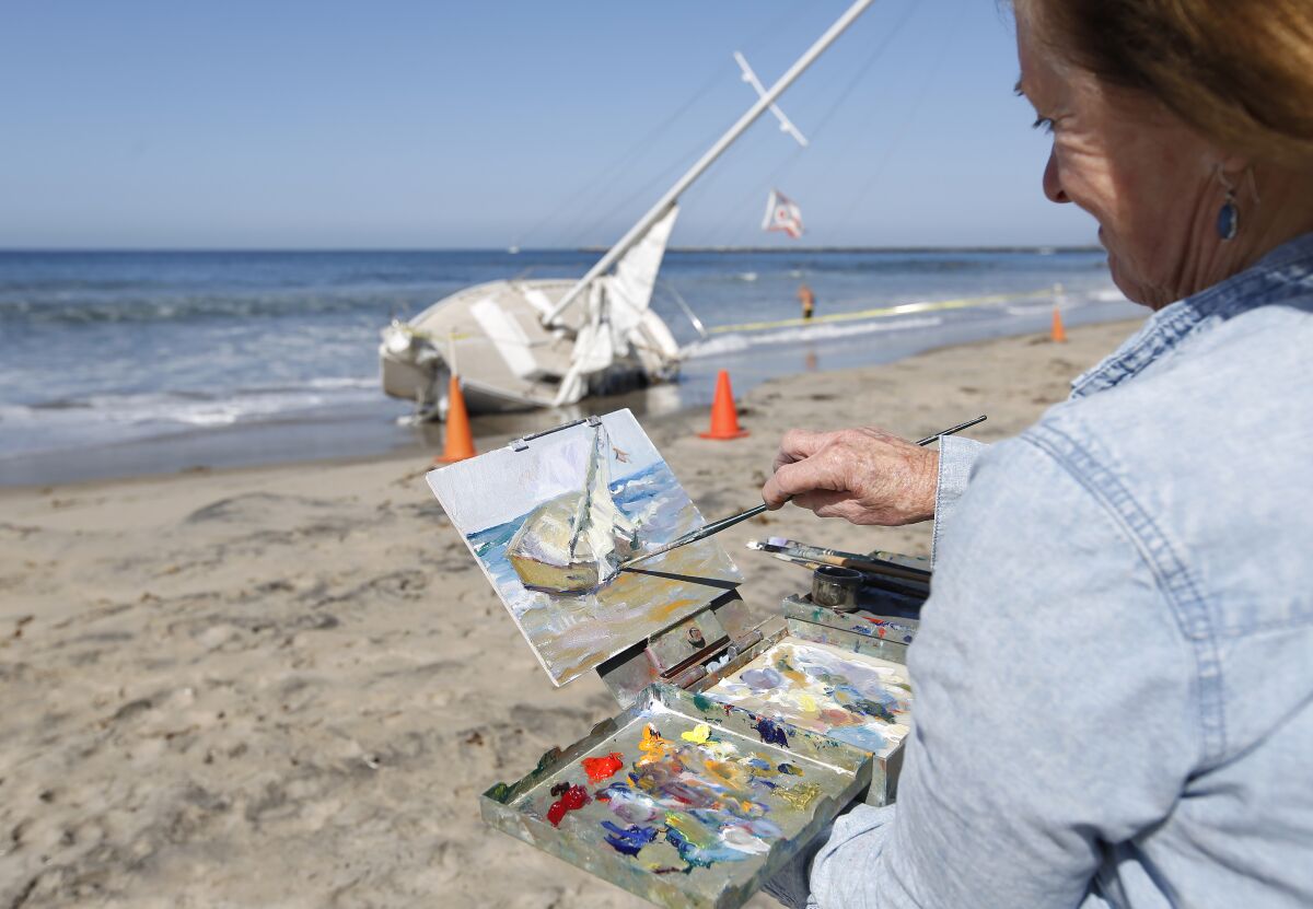 Andrea Gaye makes a painting of a boat that washed ashore in Ocean Beach on October 28, 2019. 