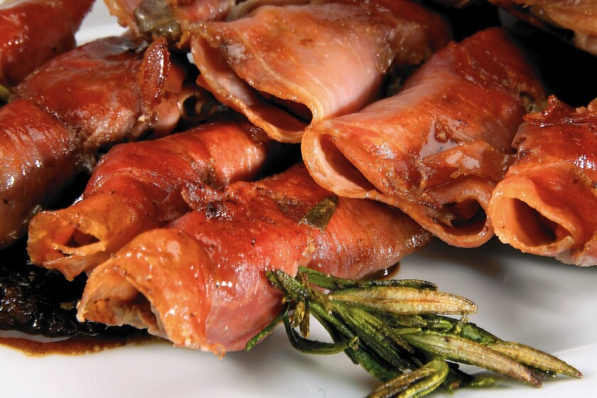 Prosciutto-wrapped chicken livers are quick fried on skewers of rosemary stems.