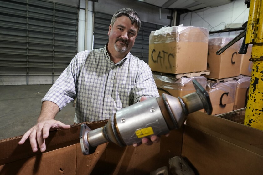 Troy Webber, owner of Chesterfield Auto Parts, holds a used catalytic converter removed from a car at his salvage yard.