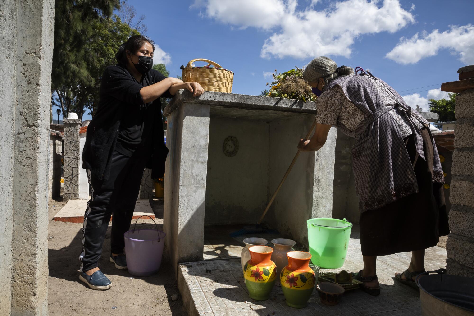 Two women work in a graveyard