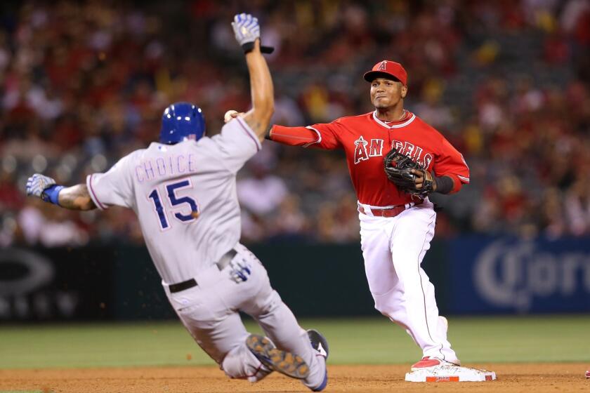 Erick Aybar makes a throw to first to complete a double play after forcing out Michael Choice in the eighth inning.