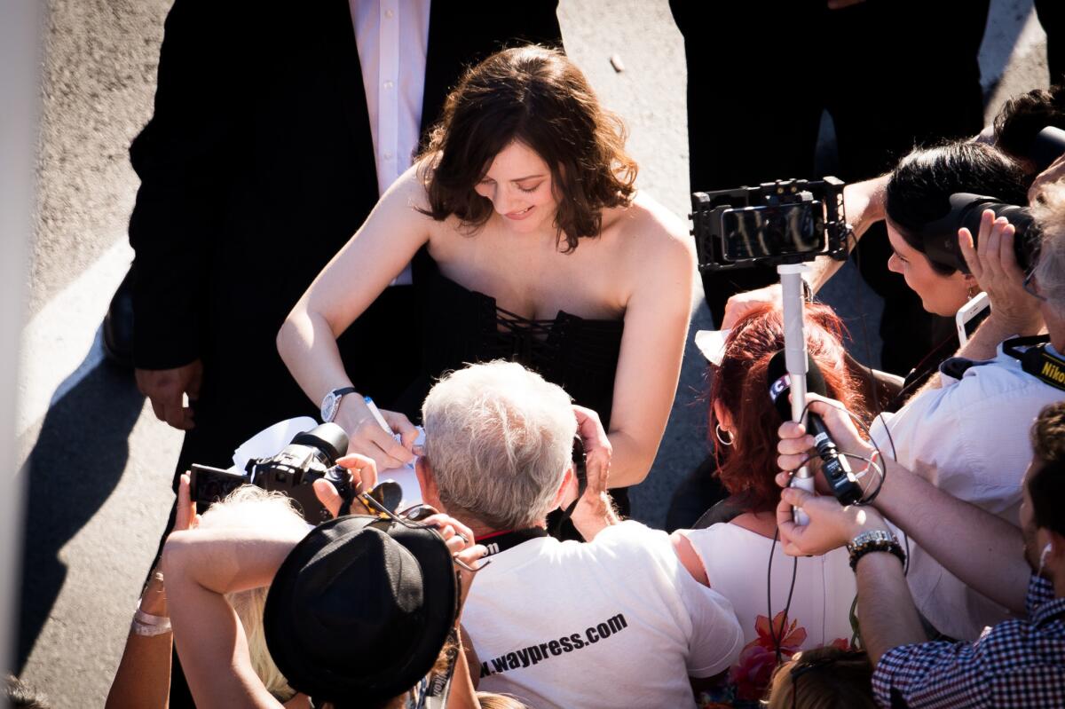Marion Cotillard signs an autograph on the red carpet for the opening gala screening of "Ismael's Ghosts (Les Fantomes d'Ismael)" at the 70th annual Cannes Film Festival.