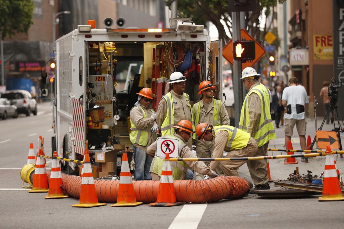 A DWP crew works near a downtown building at the corner of Wilshire and Flower in August.