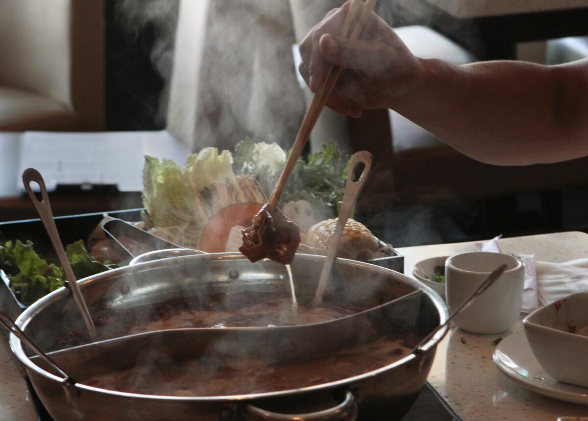 Food is cooked in a Mongolian hot pot at Little Sheep in San Gabriel, Calif.