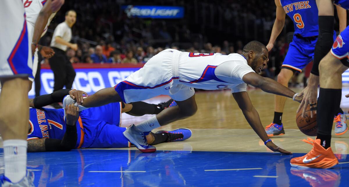 Clippers guard Chris Paul dives for a loose ball against New York forward Carmelo Anthony on Wednesday.