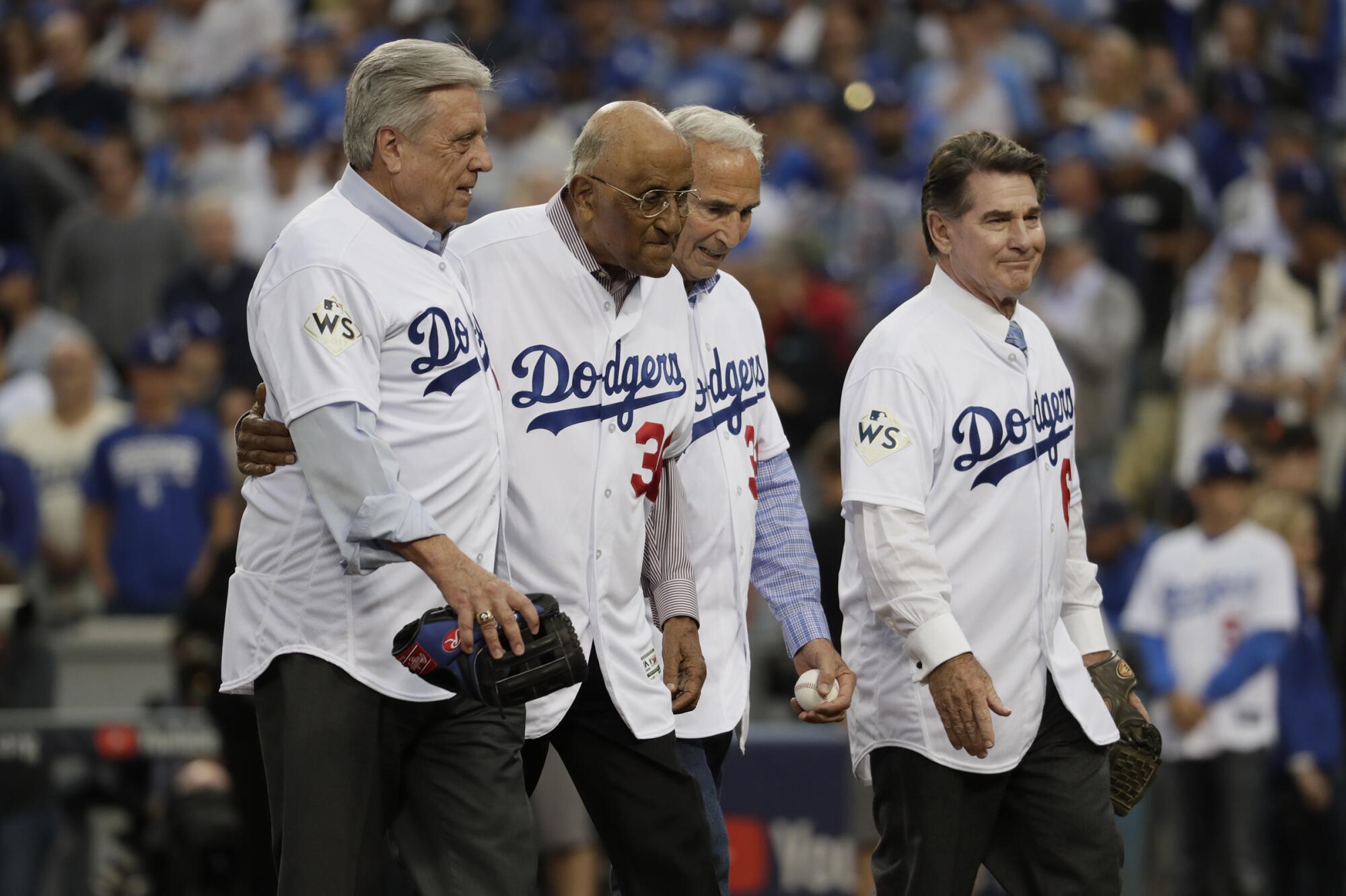 Legendary Dodgers walk off the field after the ceremonial first pitch in game seven of the World Series at Dodger Stadium.